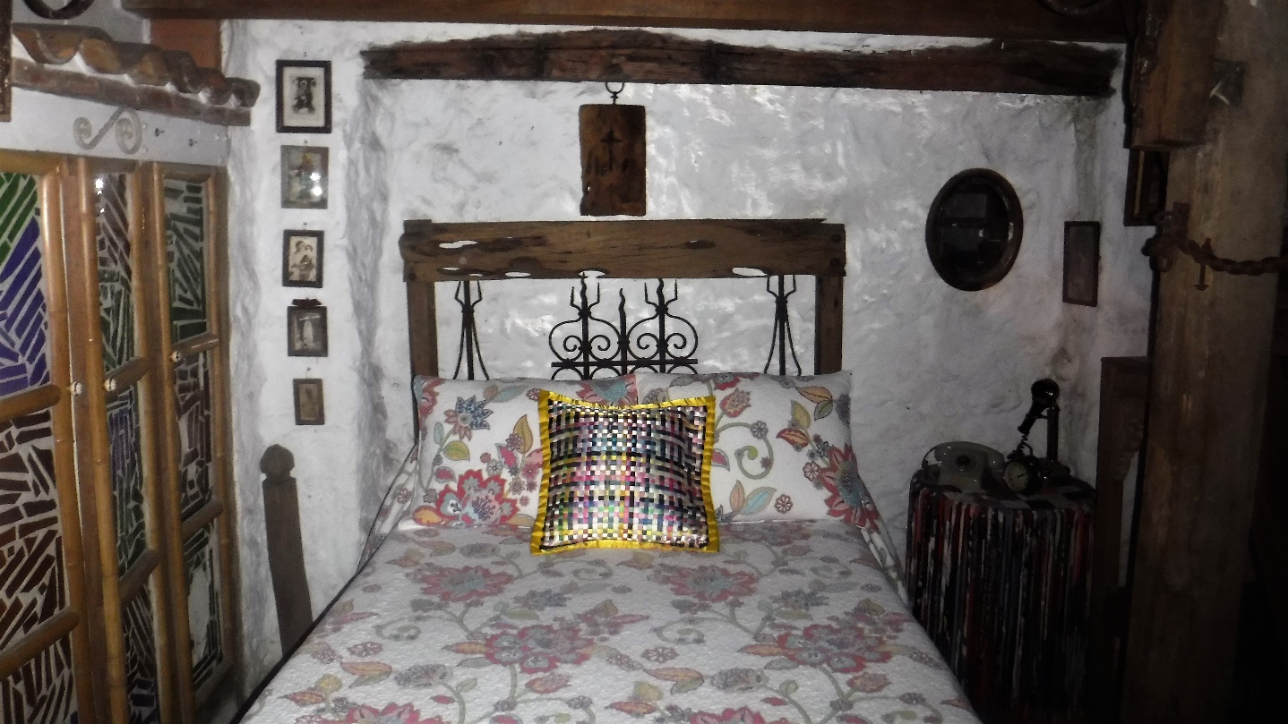 A bedroom with a bed and a chair in a room Description automatically generated