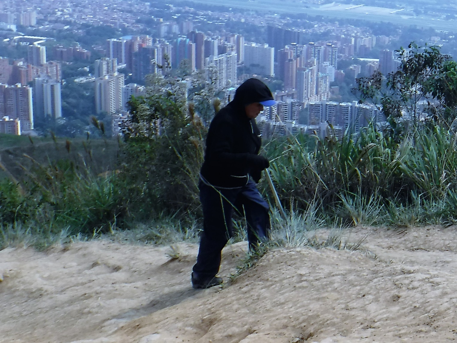 A person walking down a dirt road Description automatically generated