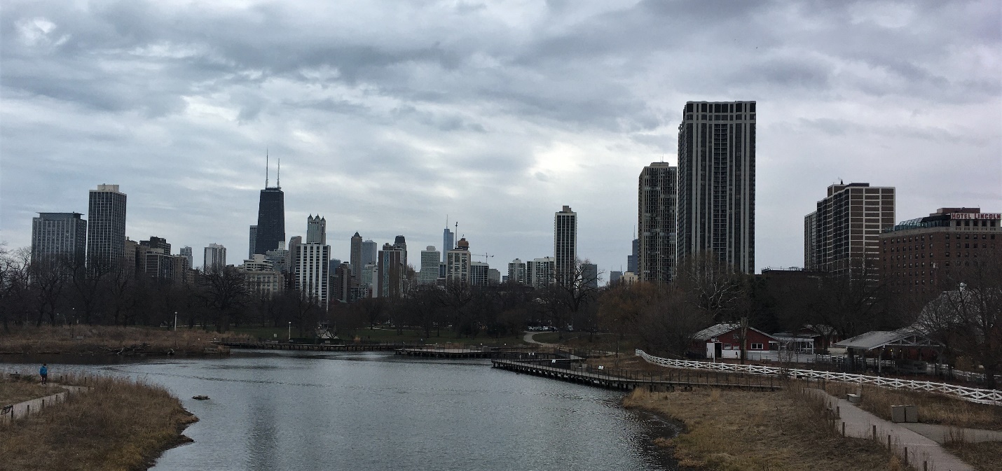 A city skyline with a body of water in the foreground Description automatically generated with low confidence