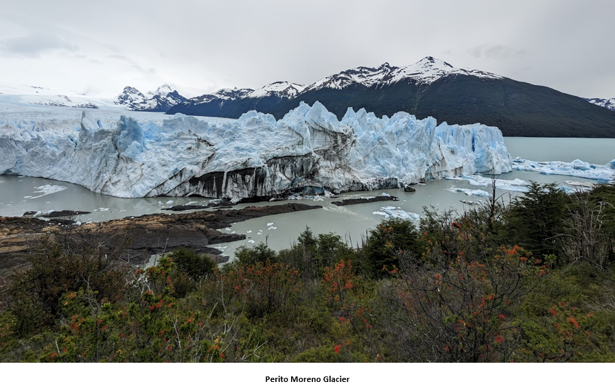 A glacier next to a body of water Description automatically generated